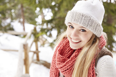 Portrait of a young woman in winter clothes and a hat wrapped in a scarf  with a big smile - a Royalty Free Stock Photo from Photocase