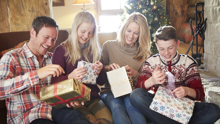 Familie öffnet Geschenke an Weihnachten - CAIF15408