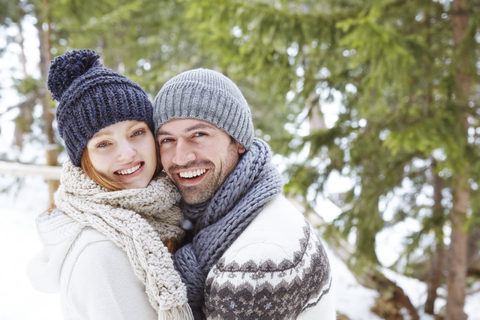 Paar, das sich im Schnee umarmt, lizenzfreies Stockfoto