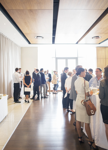 Large group of people socializing in lobby of conference center during coffee break stock photo