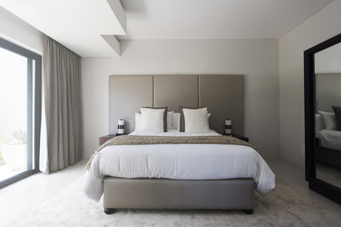 Modernes weiß-beiges Schlafzimmer mit Doppelbett, lizenzfreies Stockfoto