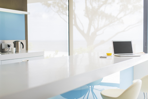 View of modern kitchen with laptop on kitchen counter stock photo