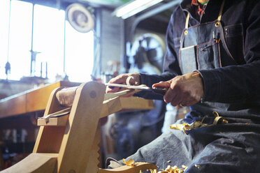 Mittelteil eines Zimmermanns, der mit einem Ziehmesser in der Werkstatt Holz spaltet - CAVF06998