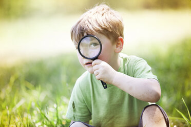 Porträt eines Jungen, der durch ein Vergrößerungsglas schaut - CAVF07043