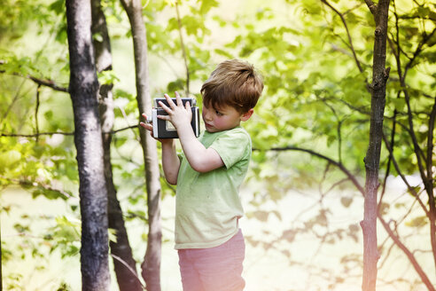 Junge fotografiert durch eine alte Kamera im Park - CAVF07044