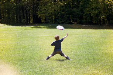 Rückansicht eines Jungen beim Frisbeewerfen im Park - CAVF07048