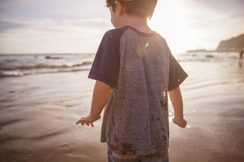 Mittelteil eines Jungen am Strand bei Sonnenuntergang - CAVF07141