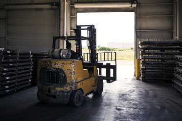 Rear view of worker driving forklift in metal industry while working - CAVF07387