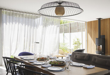 Chandelier over dining table in modern dining room - CAIF15635