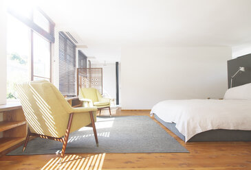 Sessel, Teppich und Bett in einem modernen Schlafzimmer - CAIF15637