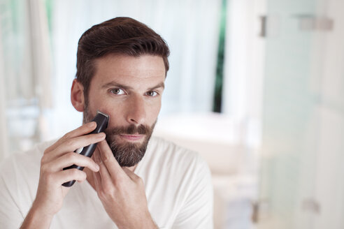 Mann beim Trimmen des Bartes im Badezimmerspiegel - CAIF15667