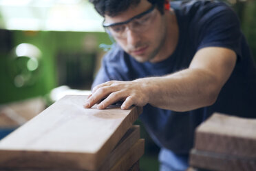 Zimmermann prüft Holzbretter in der Werkstatt - CAVF07469