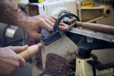 Male carpenter using handsaw in workshop - CAVF07470