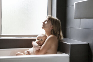 Mother relaxing with daughter in bathtub - CAVF07562