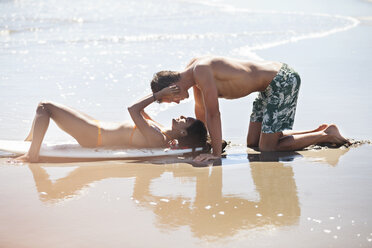 Junges Paar turtelt am Strand an einem sonnigen Tag - CAVF07620