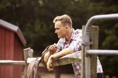 Seitenansicht eines Ranchers mit Sattel auf einem Bauernhof - CAVF07655