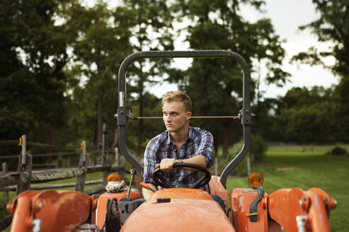 Landwirt schaut beim Traktorfahren auf dem Bauernhof weg - CAVF07691