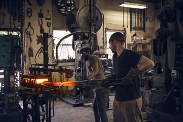 Arbeiter beim Formen von Stangen im Ofen in der Werkstatt - CAVF07719