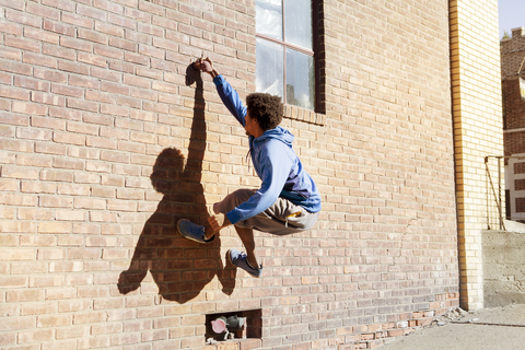 Man climbing brick wall stock photo