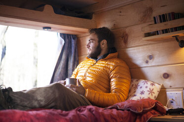Thoughtful man relaxing in camper van - CAVF07789