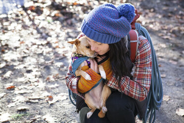 High angle view of woman embracing dog - CAVF07799