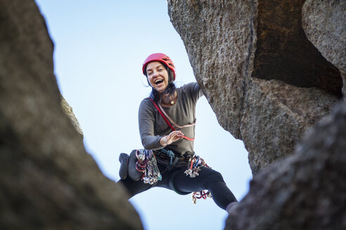 Niedriger Blickwinkel auf eine glückliche Frau beim Klettern - CAVF07805