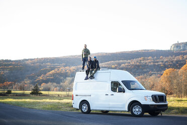 Freunde auf dem Wohnmobil gegen den klaren Himmel - CAVF07833