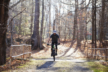 Mann beim Mountainbiken im Wald - CAVF07866