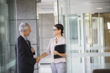 Business people shaking hands in office building - CAIF15767