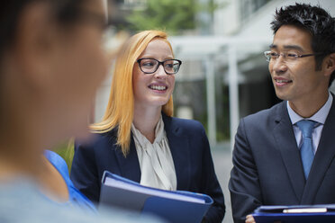 Businesspeople talking outside of office building - CAIF15793