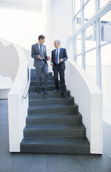 Businessmen talking on stairs - CAIF15825