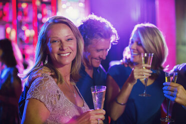 Freunde mit Champagnerflöten haben Spaß in einem Nachtclub - CAIF15831