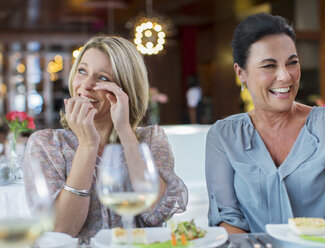 Frauen lachen am Tisch im Restaurant - CAIF15853