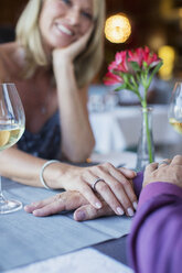 Paar hält Hände im Restaurant - CAIF15861
