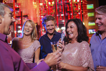 Friends singing karaoke in nightclub - CAIF15866
