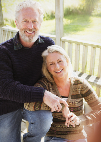 Portrait smiling senior couple on porch stock photo