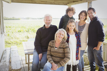 Porträt lächelnde Mehrgenerationenfamilie auf Veranda - CAIF15892
