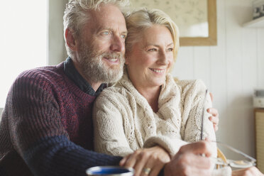 Smiling senior couple hugging and looking away - CAIF15901