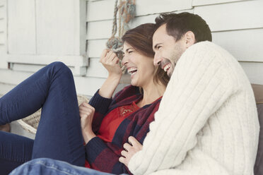 Lachendes Paar auf der Veranda - CAIF15918