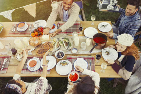 Freunde genießen das Mittagessen am Terrassentisch, lizenzfreies Stockfoto