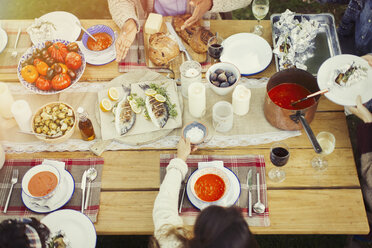 Freunde genießen das Mittagessen am Terrassentisch - CAIF16023