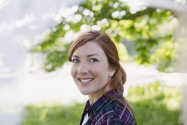 Portrait smiling woman with red hair outdoors - CAIF16050