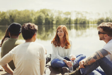 Friends talking at sunny lakeside - CAIF16051
