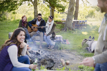 Freunde, die am Lagerfeuer Gitarre spielen - CAIF16067