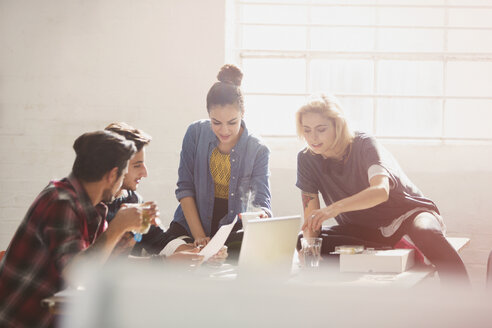 Kreative junge Geschäftsleute beim Brainstorming am Laptop in einem sonnigen Büro - CAIF16120