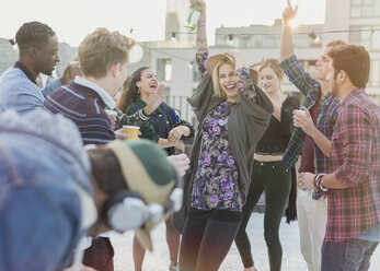 Verspielte junge erwachsene Freunde tanzen auf einer Dachterrassenparty - CAIF16144