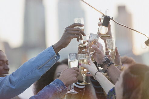 Junge erwachsene Freunde stoßen auf einer Party mit Sektflöten an - CAIF16146