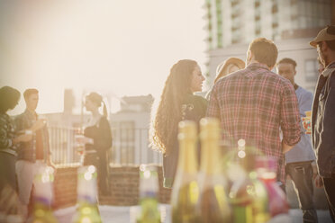 Freunde junger Erwachsener treffen sich auf einer sonnigen Dachterrassenparty - CAIF16152