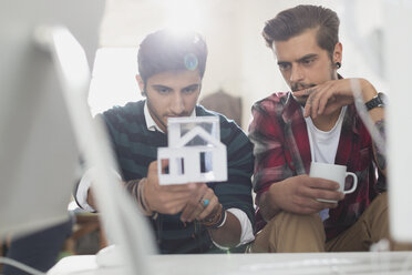 Young male architects examining house model - CAIF16167