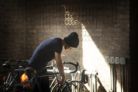 Mann schaut auf Fahrrad im Gepäckträger, lizenzfreies Stockfoto